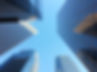 Upward view of modern skyscrapers in Downtown Los Angeles against a clear blue sky, highlighting the city’s architectural style
