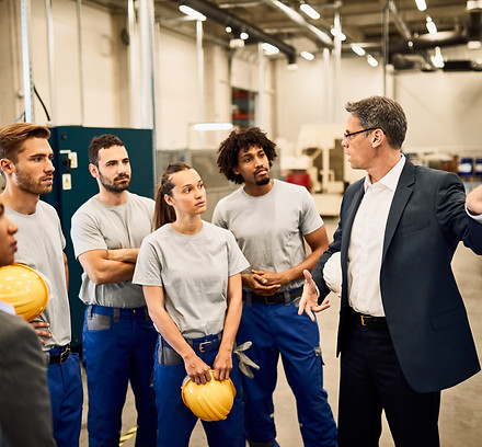 mid-adult-businessman-giving-presentation-group-industrial-workers-factory.jpg