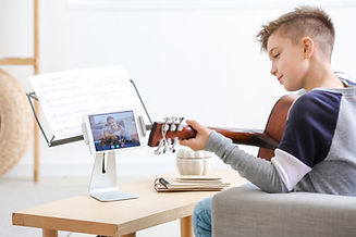 Little boy taking music lessons online at home.jpg
