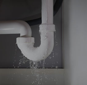 Professional plumber repairing a leaking pipe