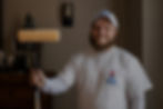 painter dressed in white, holding paint roller