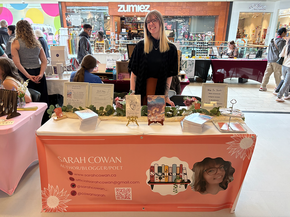 A girl standing in front of a table at a market, selling two poetry books.