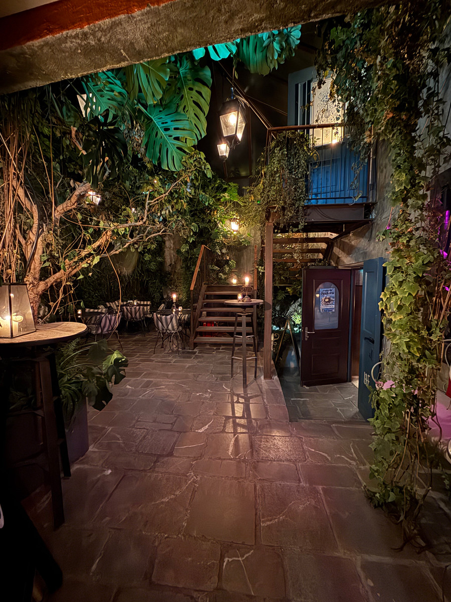 The planted courtyard entrance to Twent's by lantern light