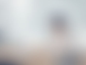 A Google Ads freelancer working at a laptop in a modern office, reviewing analytics displayed as floating digital charts. A notebook, coffee mug and desk accessories are placed on the table.