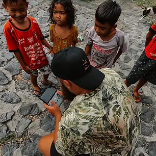Kinder schauen bei Drohnen Bedienung einem Mann in Bali zu