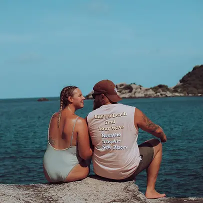 Paar sitzt auf Klippe schaut aufs Meer Hin Wong Bay Koh Tao, Thailand