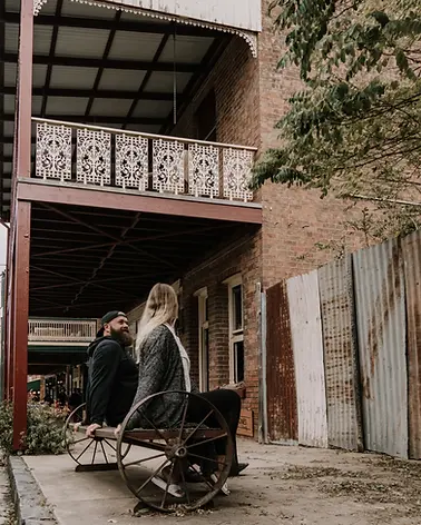 Frau sitzt vor altem Salon in Kleinstadt an Ostküste, Australien