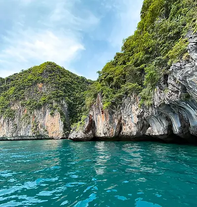 Steile Kalksteinfelsen ragen aus türkisblauem Meer vor Koh Phi Phi in Thailand.