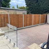 close board panels with concrete posts and concrete gravel balustrades glass panels