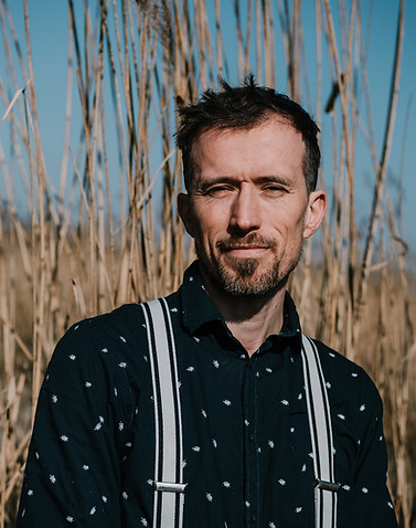 Sam Persoon is procesbegeleider bij het oprichten van natuurlijke eetbare tuinen en staat in het riet