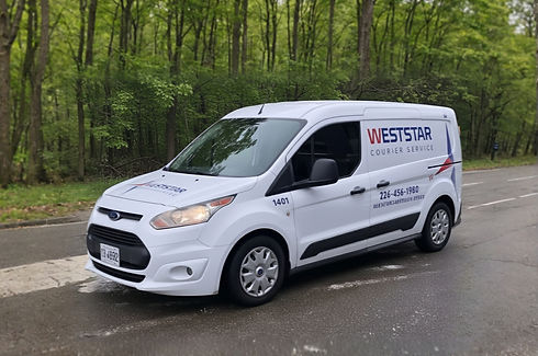 A white Ford Transit Connect van, marked with "WESTSTAR COURIER SERVICE" and a phone number (226-456-1980), parked on a paved road with green trees in the background.