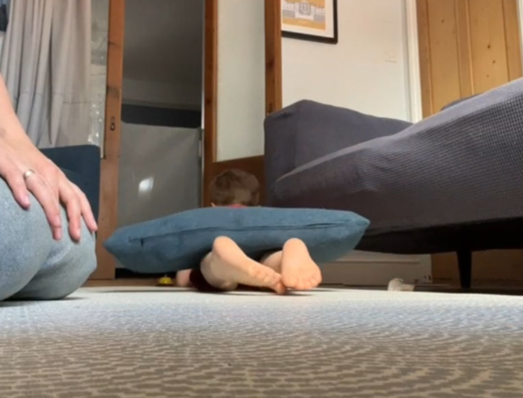 child commando crawling with a pillow over his legs