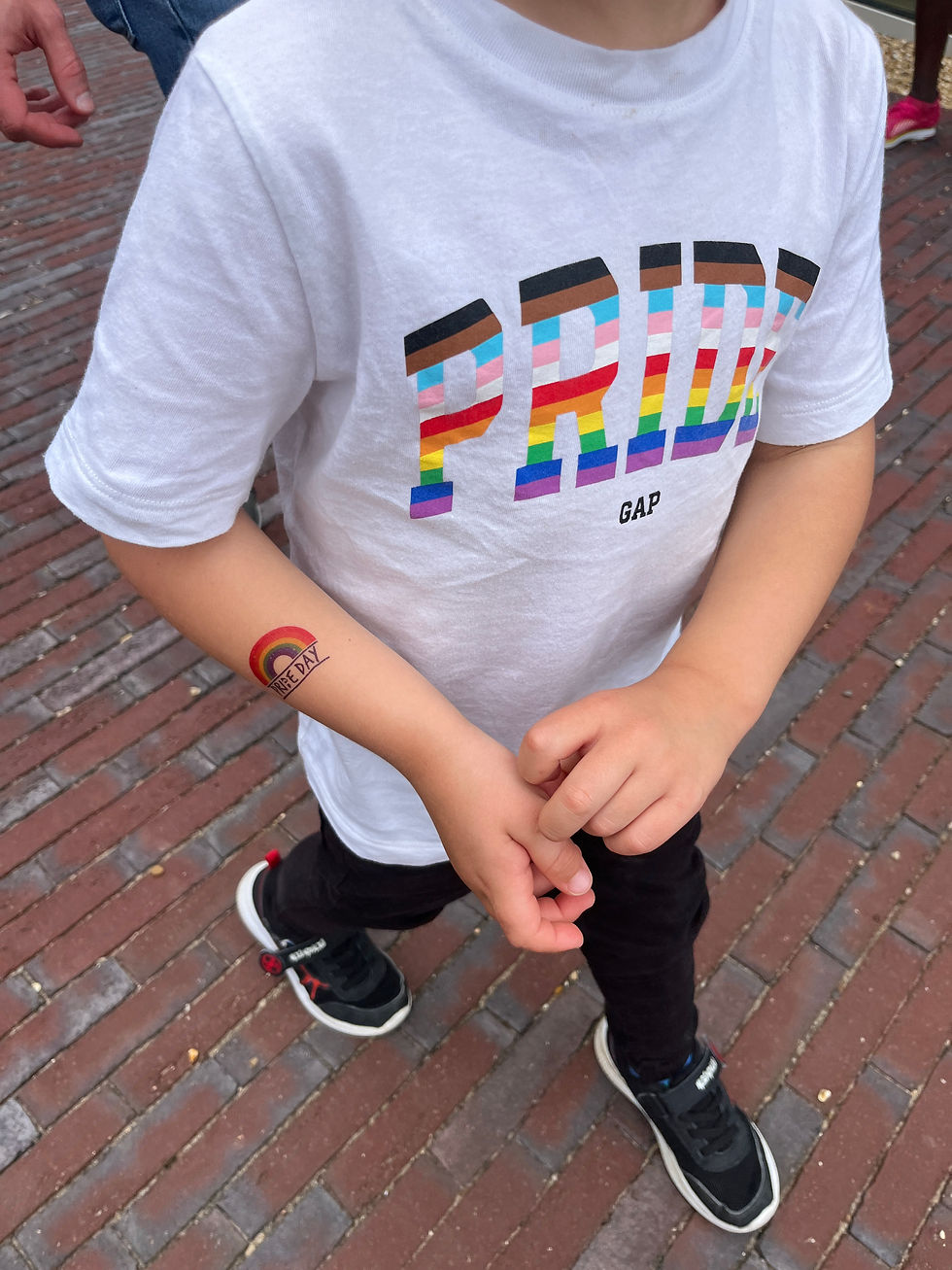 A child wearing a white tshirt with PRIDE in rainbow lettering