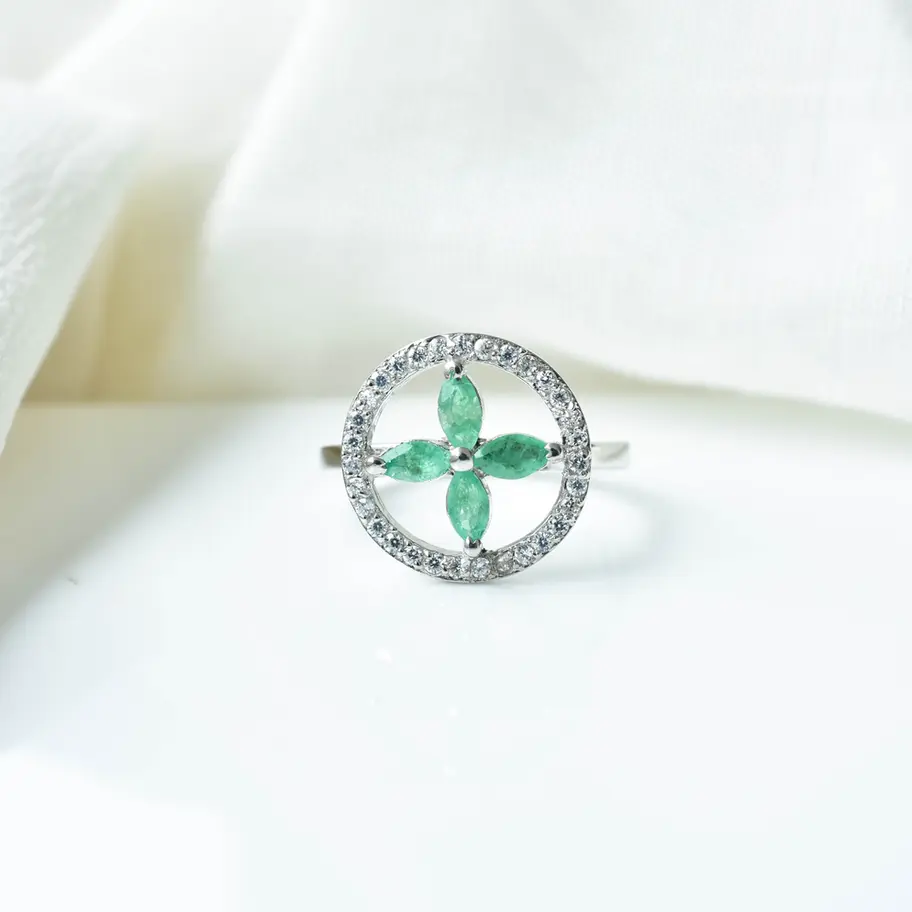 Emerald green floral gemstone ring with American diamond accents in 925 sterling silver worn on hand, elegant statement jewel