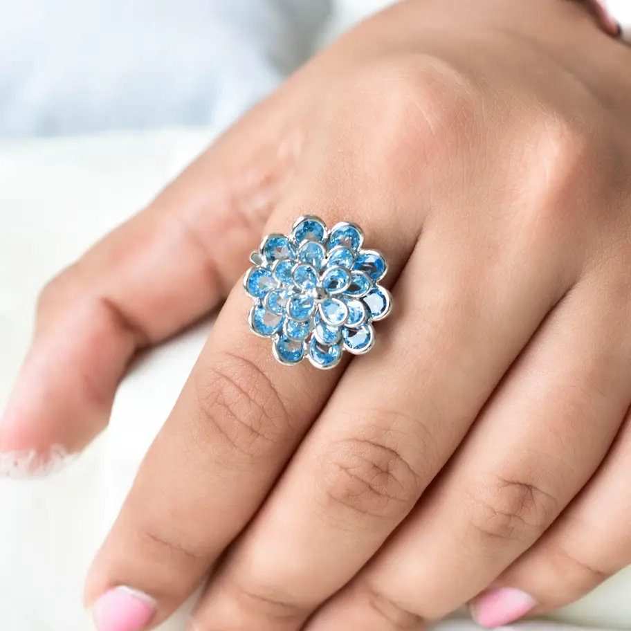 Sky blue topaz floral cluster ring in 925 sterling silver worn on hand, vibrant statement gemstone jewellery