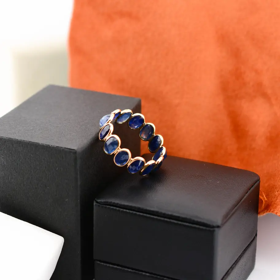 Elegant 18K solid gold eternity ring featuring alternating ruby and emerald gemstones. A vibrant yet timeless fine jewellery