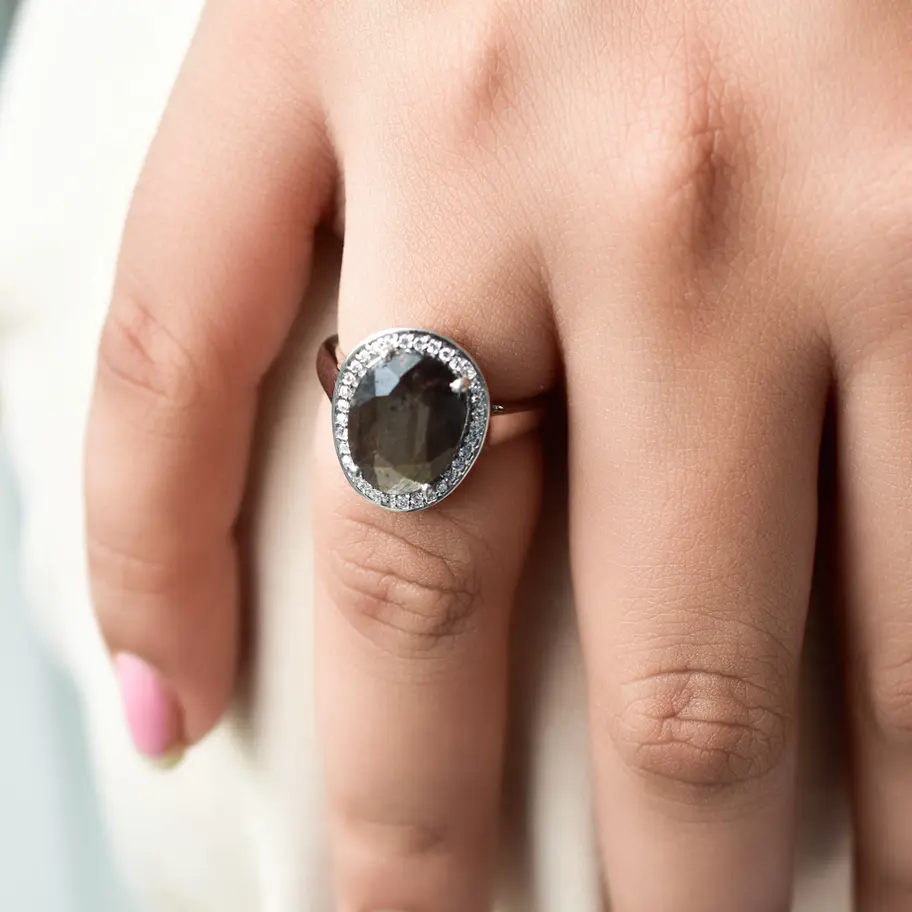 925 sterling silver sapphire gemstone ring styled on white fabric background, minimalist editorial jewellery shot