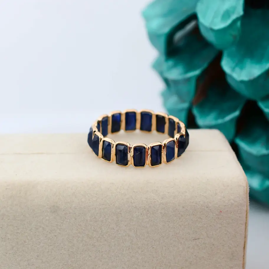 Minimalist 18K gold blue sapphire ring with natural sapphire gemstones on a clean white background.