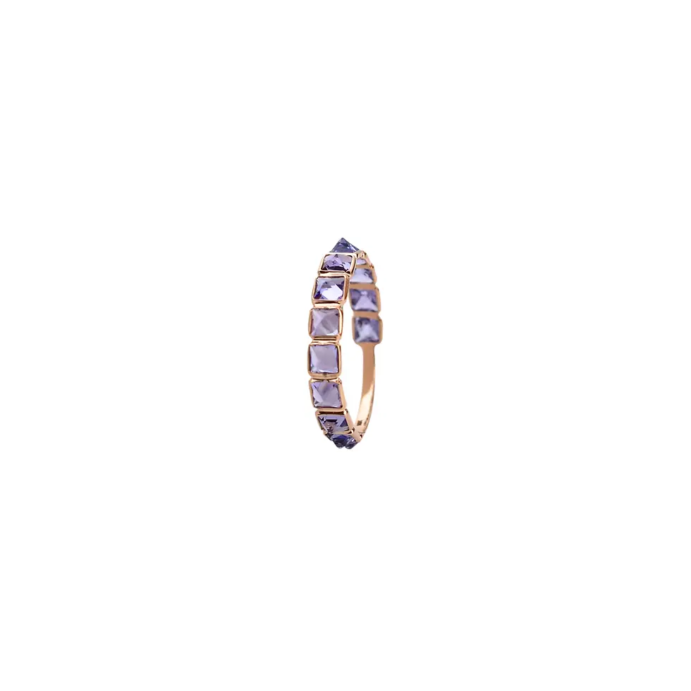 18K solid gold eternity ring with natural tanzanite gemstones displayed on a beige jewelry stand.