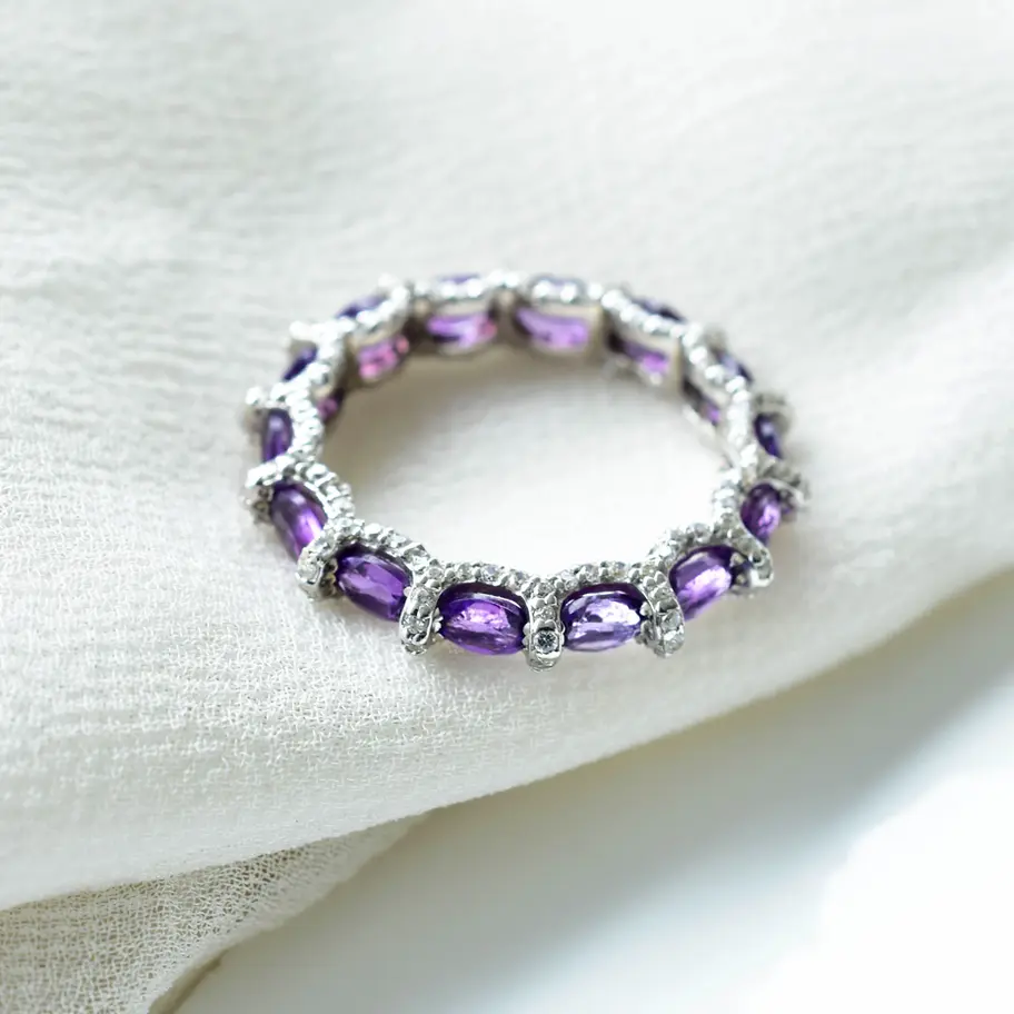 Sterling silver eternity ring with natural amethyst stones arranged in slim circular band