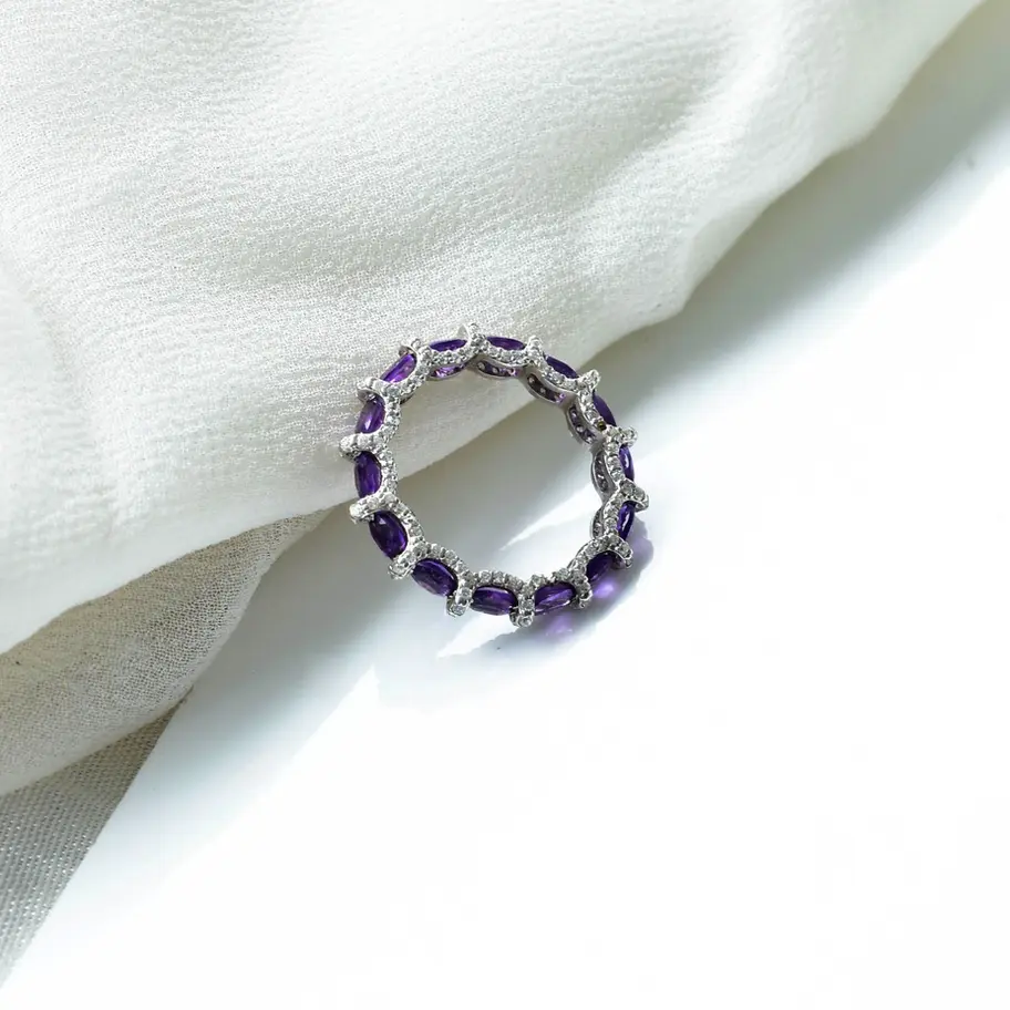 Sterling silver eternity ring with natural amethyst stones arranged in slim circular band
