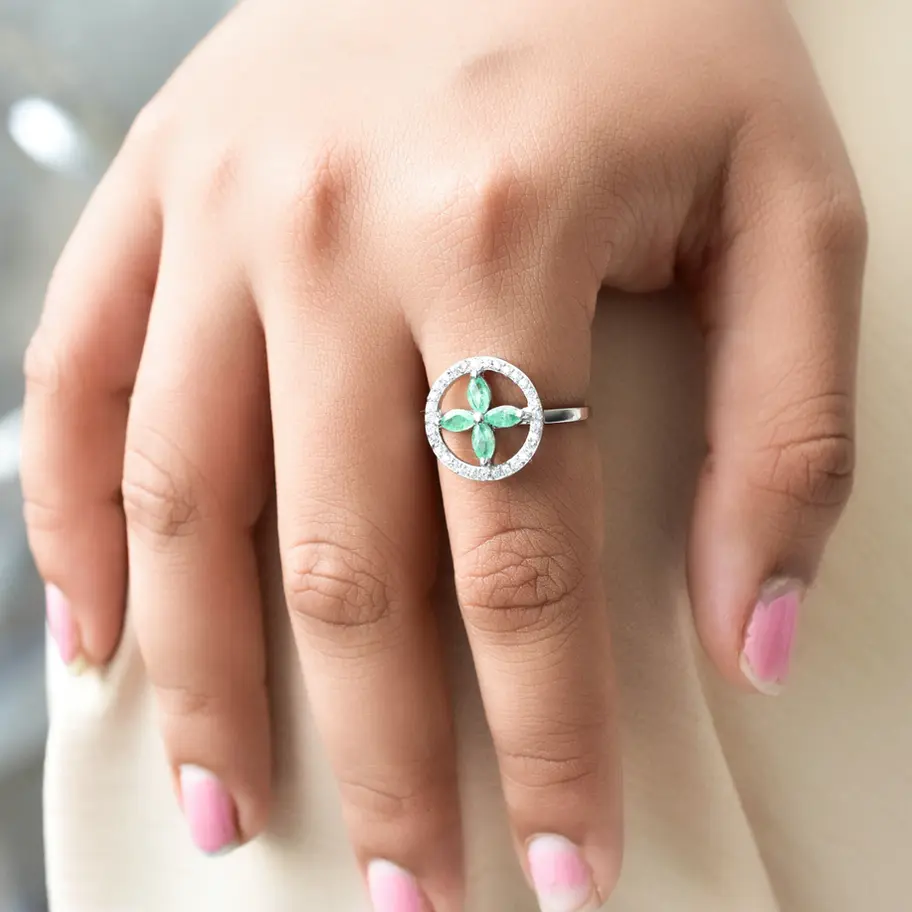 Emerald green floral gemstone ring with American diamond accents in 925 sterling silver worn on hand, elegant statement jewel
