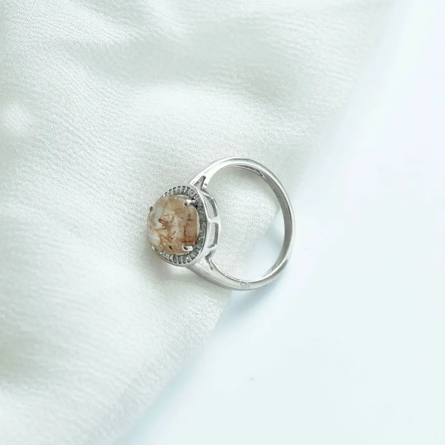 925 sterling silver golden rutilated quartz ring photographed on soft white fabric background