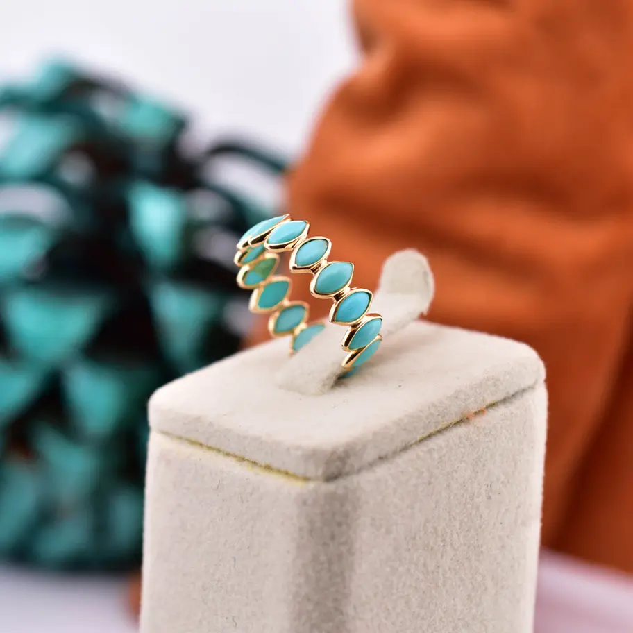 18K gold natural turquoise eternity ring with oval turquoise gemstones displayed on a black jewelry box.