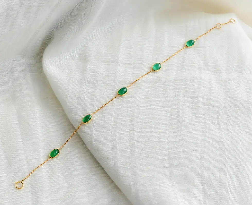 Minimal 18K gold emerald bracelet with spaced oval green stones on fine gold links