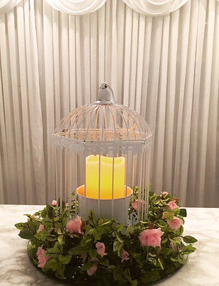 White birdcage centre piece with LE pilla canles & pink rose floral garland