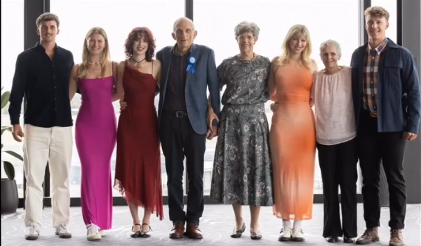 Stephanie’s parents standing with grandchildren, celebrating together and highlighting the strength of family connections.