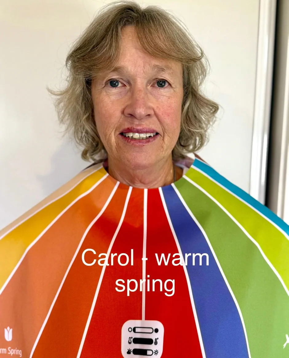 Stephanie Rumble’s happy client Carol smiles during a colour analysis session, wearing a Warm Spring drape to reveal her best shades.