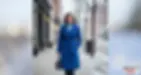 Woman walks confidently in the snow wearing a bright blue winter coat, showing style, warmth, and practicality for cold weather.