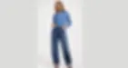 Woman wearing barrel jeans with curved leg shape, styled with denim shirt for a modern relaxed look.