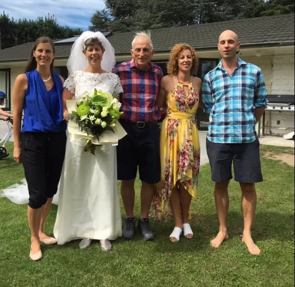 Stephanie’s parents surrounded by family members, dressed for a special occasion, honoring love and multigenerational bonds.