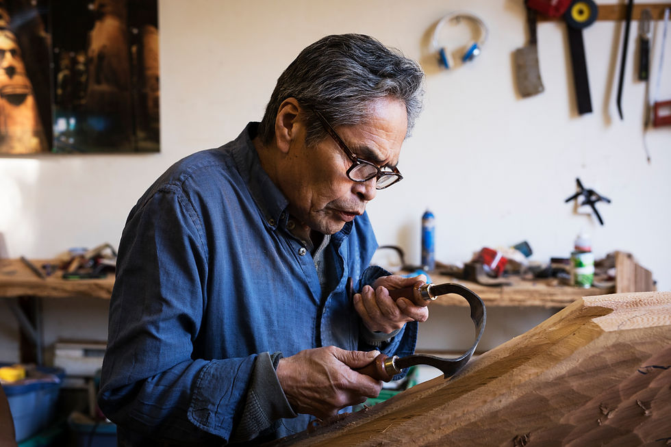Master canoe carver Joe Martin shaping a canoe in his shop.