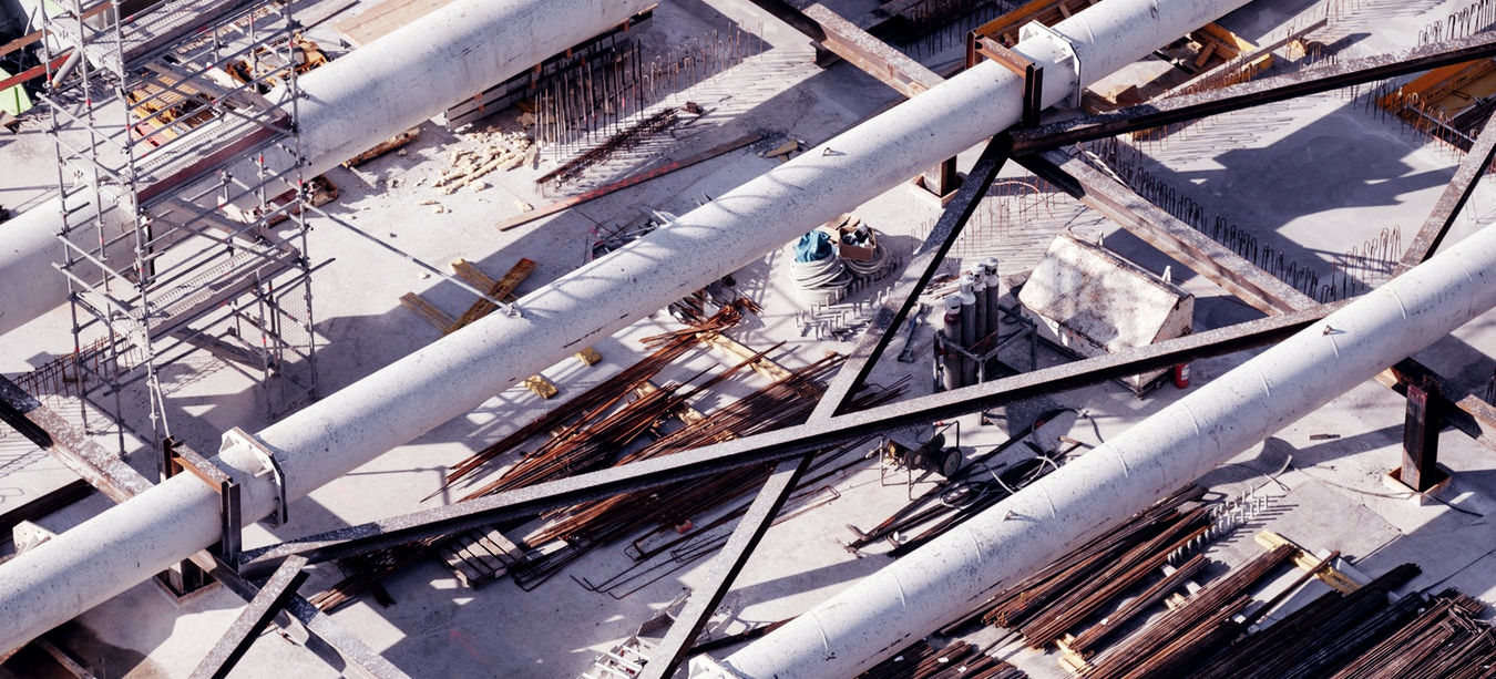 Large industrial pipes and scaffolding at a construction site.