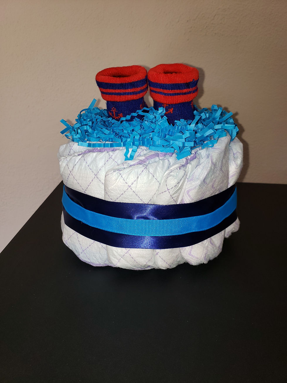 Thumbnail: Mini Blue Diaper Cake with Anchor Socks and Layered Ribbon