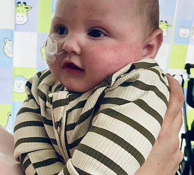 Happy baby with enteral feeding tube, a AHNHS participant.