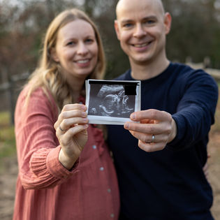 Schwangerschaftsfotografie Outdoor in den Dünen: werdende Eltern mit Ultraschallbild