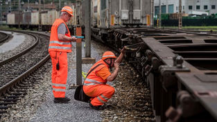 Spezialisten prüfen Räder von Güterwagen.