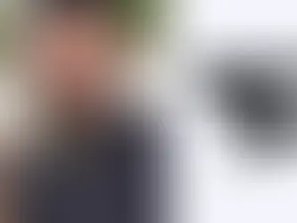 Faze Banks with tattoos and a cap holds up a middle finger, looking serious. He's outdoors with grass and pavement. FaZe Clan logo on the right.