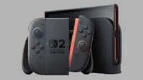 Nintendo Switch with black Joy-Con controllers, one with red trim. Text reads "Nintendo Switch 2." Set against a gray background.