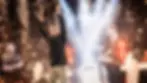 SC2 Gamer Serral holding trophy amid fireworks on stage. "Esports World Cup" text on pedestal. Celebratory mood, bright lights, confetti in background.