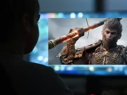 a boy watching to monitor with black myth wukong poster on it