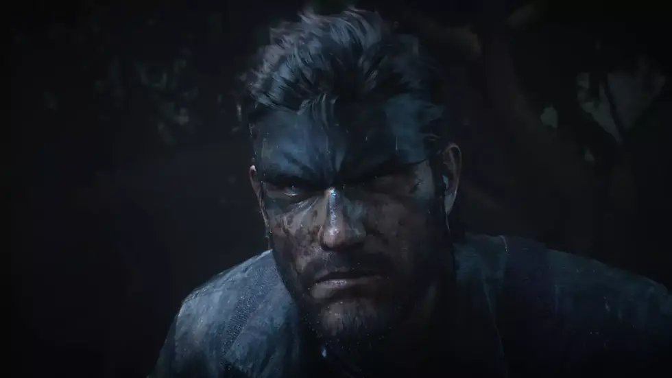 A rugged man with a headband, a serious expression, and a dirty face, stands against a dark, blurred forest background. its from Metal Gear Solid Delta: Snake Eater.