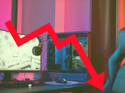 Computer setup with monitor, headset, and chair in colorful lighting. A bold red arrow points downward, indicating decline or decrease.