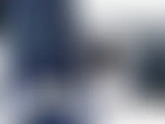 PlayStation 5 and Xbox Series S with controllers on a starry background. White and black consoles, contrasting against the cosmic blue.