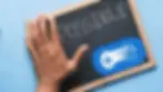 Hand on a chalkboard with "POSSIBLE" written. Blue background with a blue gaming controller icon on the board. Motivational vibe.
