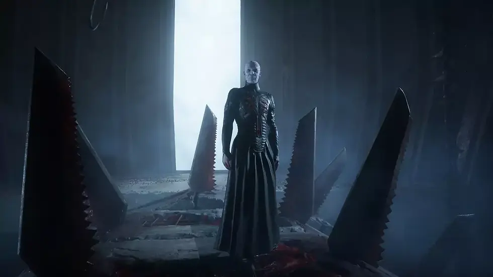A figure stands in a dark room with towering, jagged saw-like blades. The light from a large doorway casts an eerie glow, creating a tense mood. its boss from Clive Barker’s Hellraiser Revival video game.
